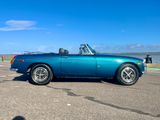 an image of a blue convertible car parked in a parking lot