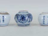 trois vases bleus et blancs ornés d'inscriptions asiatiques