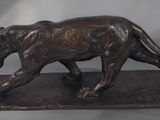 bronze statue of a tiger on a marble base on a gray background