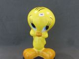un gros plan sur une figurine représentant un oiseau jaune posé sur un socle bleu