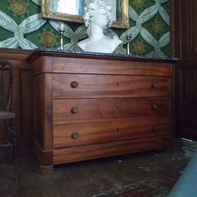 une commode en bois surmontée d'un buste en marbre