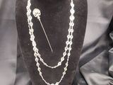 un collier et une broche posés sur un mannequin