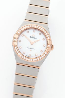 a close up of a watch on a white surface with diamonds