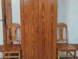 two wooden chairs and a cabinet in a room