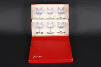 a red box with six wine glasses in it on a black surface
