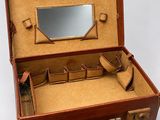 a brown suitcase with a mirror in it on a white surface