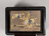 a small box with a painting on it hanging on a wall