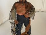 a figurine of a man holding a fish on a stand