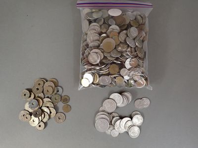 un sac de pièces posé sur une table à côté d'une pile de pièces