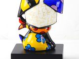 brightly colored cat figurine on a black base on a white background