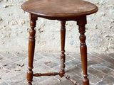 a small wooden table with a wooden top on a brick floor