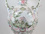 un grand vase avec un tableau posé sur une table