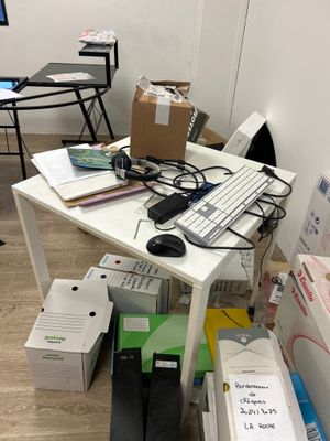 un bureau sur lequel se trouvent un clavier, une souris et d'autres objets