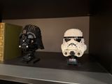 two star wars helmets on a shelf next to a book