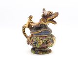 une figurine représentant un dragon posée sur une théière
