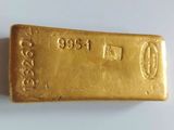 a close up of a gold bar on a white surface