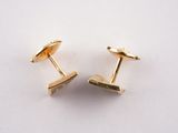 two pairs of gold plated cufflinks on a white surface