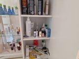 a small cabinet with a lot of hair products in it