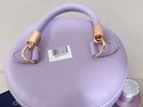 purple purse sitting on top of a wooden table next to other items