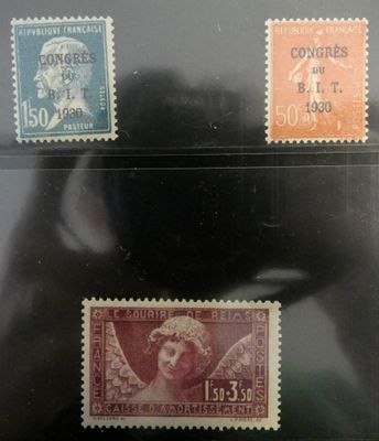trois timbres de couleurs et de tailles différentes sont posés sur une surface noire