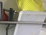 a yellow hat on top of a rack in a garage