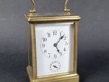 a small gold clock with a white face on a table