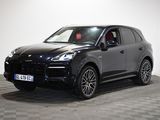 Une Porsche Cayenne noire est garée sur un sol à damier.