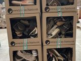 Des cartons de chaussures sont empilés les uns sur les autres dans un entrepôt