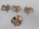 four silverware pieces are sitting on a white surface