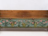 an old wooden magazine rack with flowers painted on it