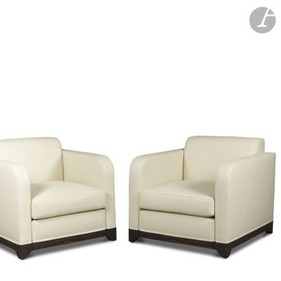 deux fauteuils en cuir blanc placés l'un à côté de l'autre sur une surface blanche