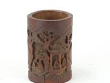 a small wooden cup with carvings of animals on it