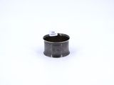 un gros plan d'une petite tasse noire posée sur une surface blanche