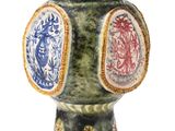 un vase vert orné d'un motif rouge et bleu