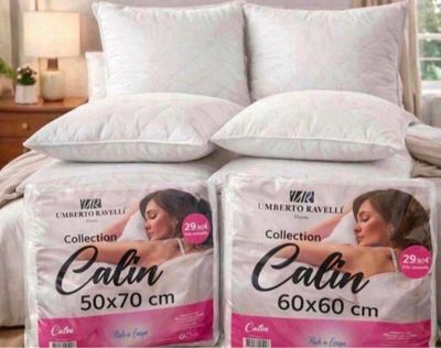 two boxes of calin pillows on a bed in a bedroom