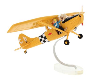 yellow toy airplane with a woman sitting in the cockpit on a white base
