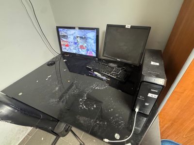 a computer desk with two monitors and a keyboard on it