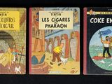 trois livres pour enfants sont alignés sur une surface noire