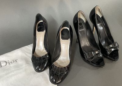 three pairs of black shoes sitting on top of a white bag