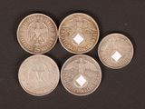 six different types of coins are shown on a black surface