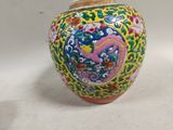a vase with a colorful design on it sitting on a white surface