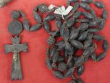 plusieurs perles noires et une croix sur un fond rouge