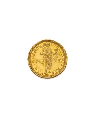 gros plan d'une pièce d'or sur une surface blanche