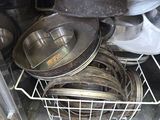 many pots and pans stacked in a metal basket