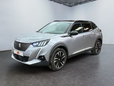 un SUV argenté garé dans une pièce blanche au sol noir