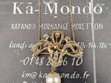 une photo d'un collier auquel est suspendue une perle