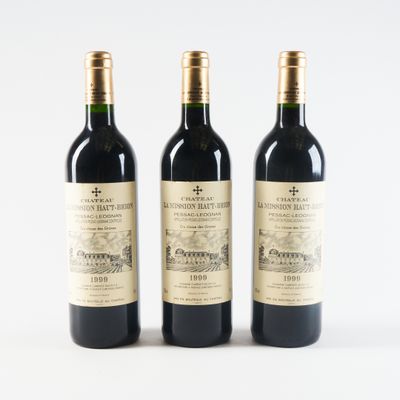 three bottles of wine sitting next to each other on a white surface