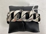 silver chain bracelet on a black pillow on a white background
