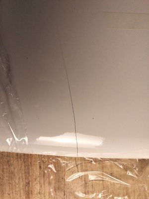 a piece of plastic covering the bottom of a refrigerator