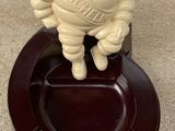 a small statue of a man on top of a ashtray